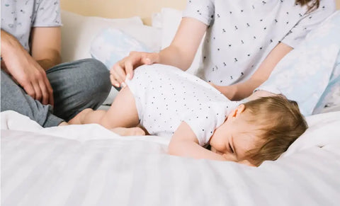 A Baby Boy Lying On His Stomach On The Bed
