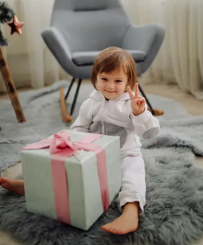 A Baby Girl Receiving A Large Box Of Gift