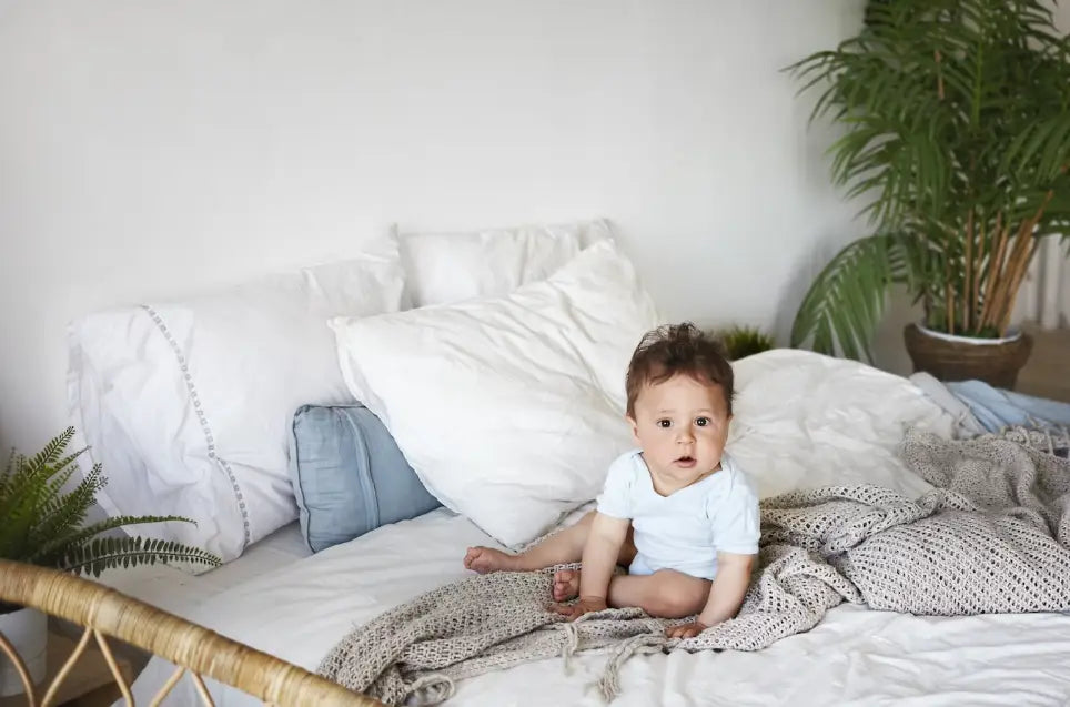 A Baby Lying On The Bed