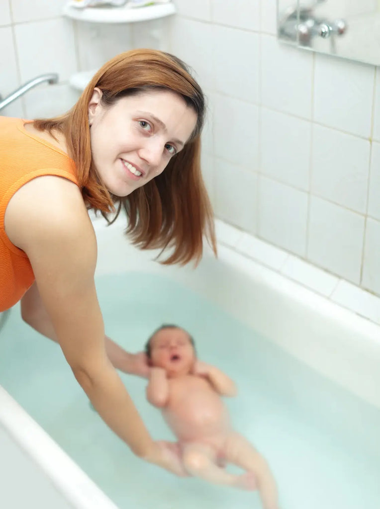 A mother bathes newborn baby bath