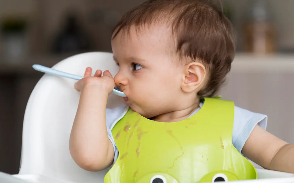 An adorable baby playing with food