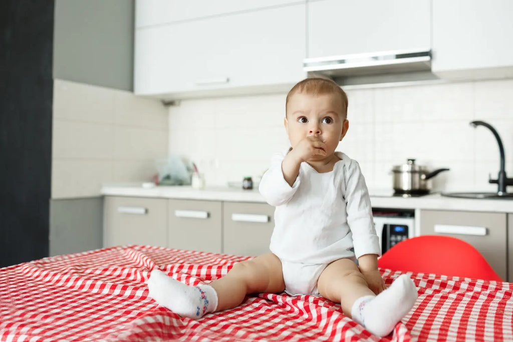 Lovely little baby sitting kitchen table