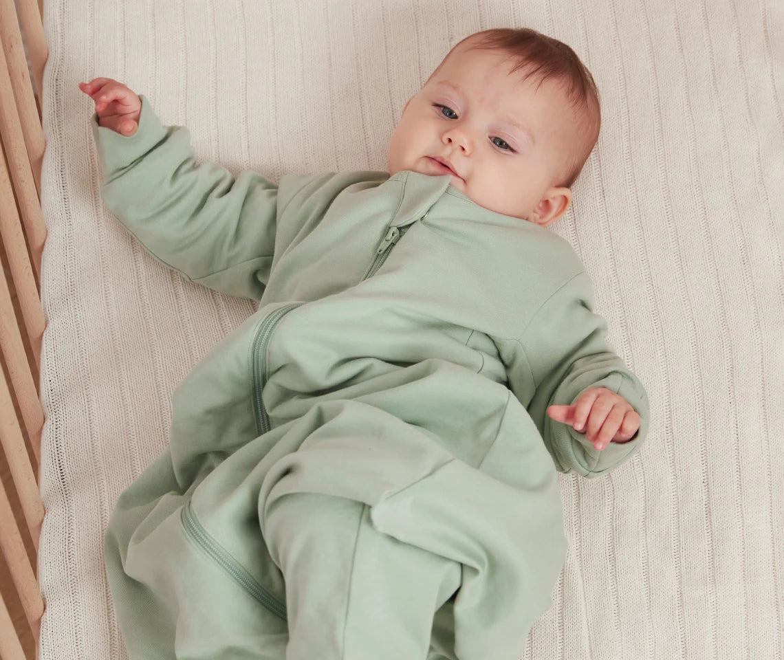 a baby in a too big sleep sack