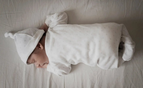 portrait baby sleeping white sheets